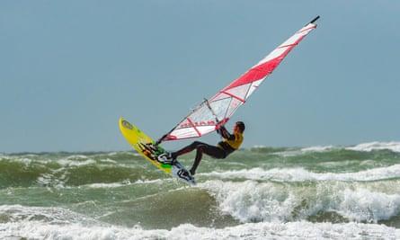 Windsurfer jumps high above the rough sea at West Wittering beach on the south coast of England, Nr. Chichester, West Sussex, UK.